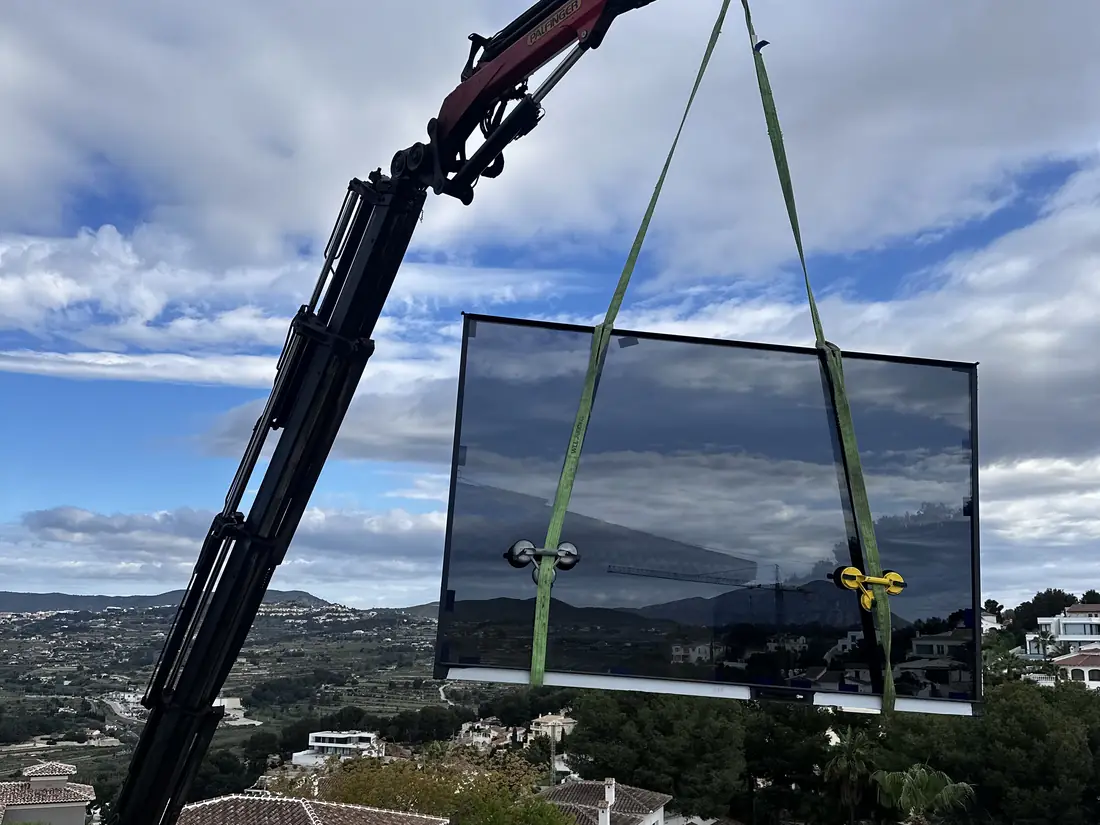 Vidrio de gran formato izado con grúa hasta la obra