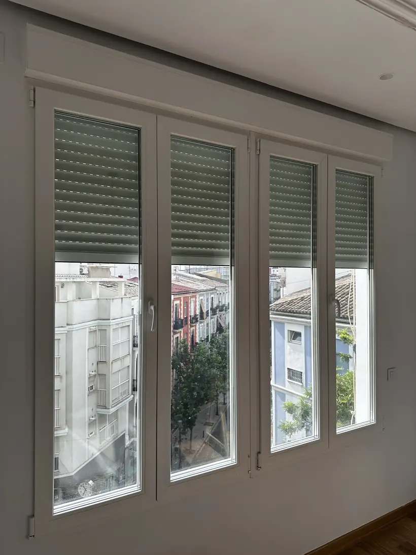 Salón con toda la pared de ventanas nuevas y persianas
